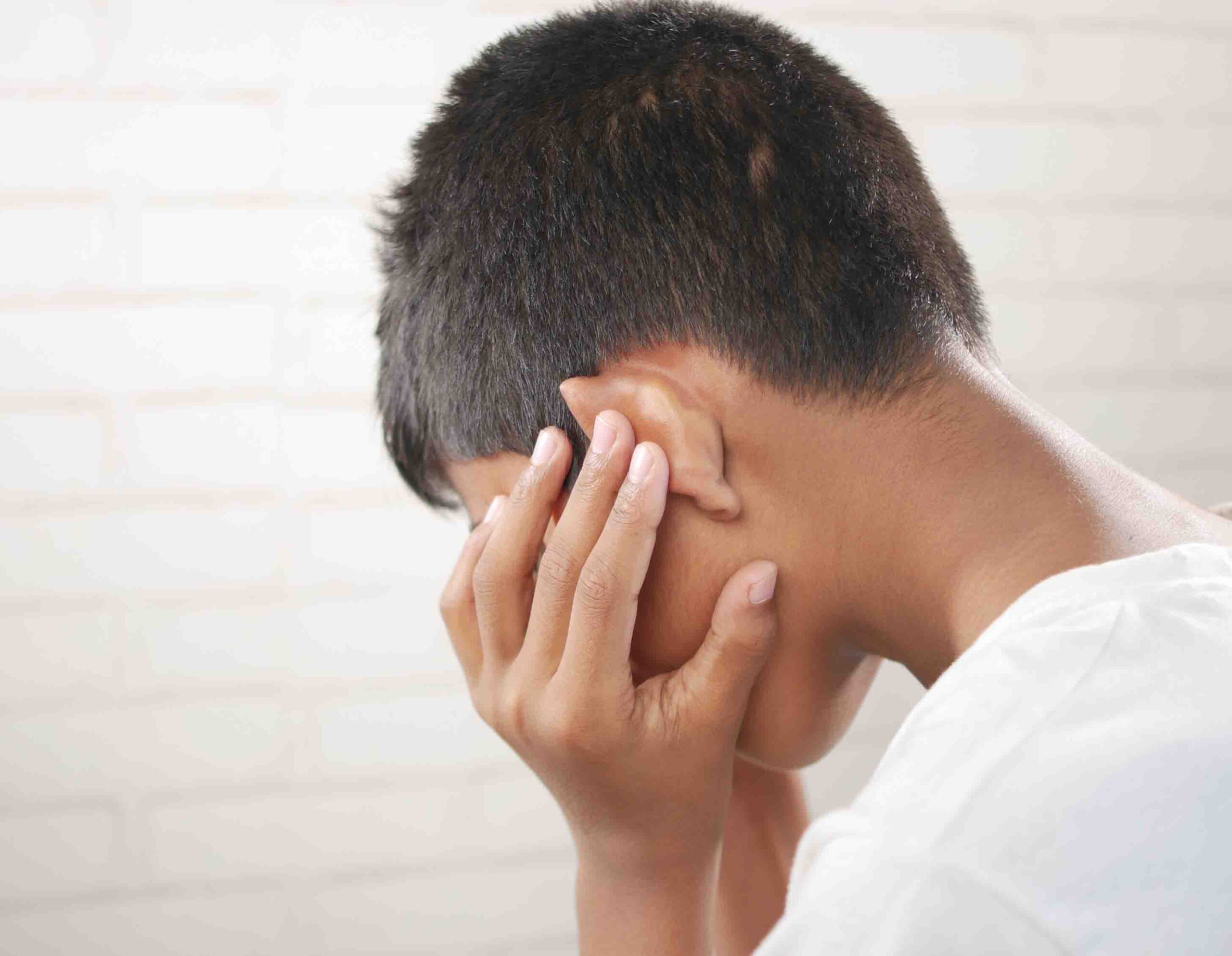 Ragazzo che si tiene l&rsquo;orecchio per fastidio dovuto ad acufeni o ronzii persistenti