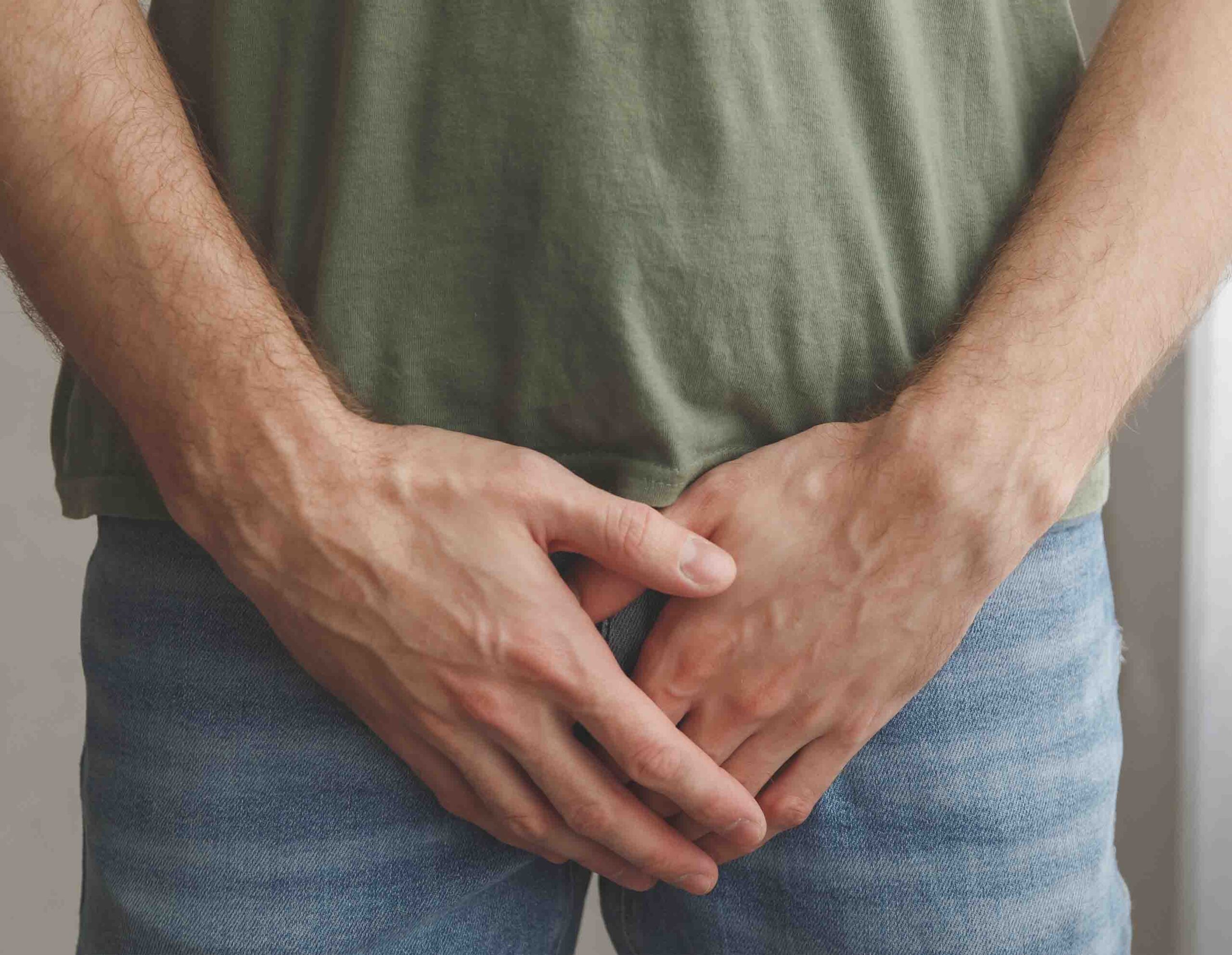 Persona che si tiene l&rsquo;area pelvica con le mani, simbolo di dolore e disfunzioni del pavimento pelvico
