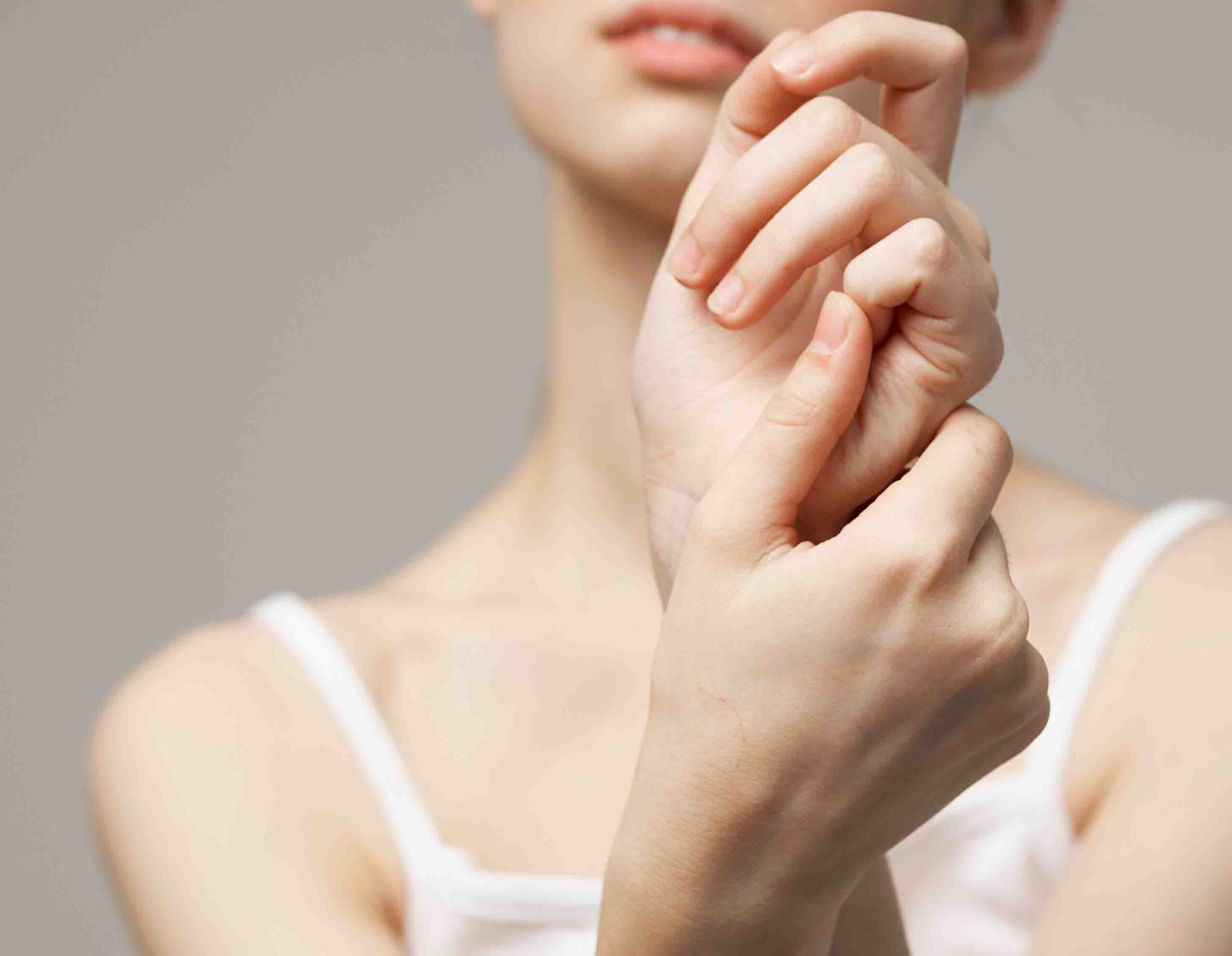 Donna con dolore e rigidit&agrave; al polso, esempio di distonia neurovegetativa con sintomi fisici diffusi