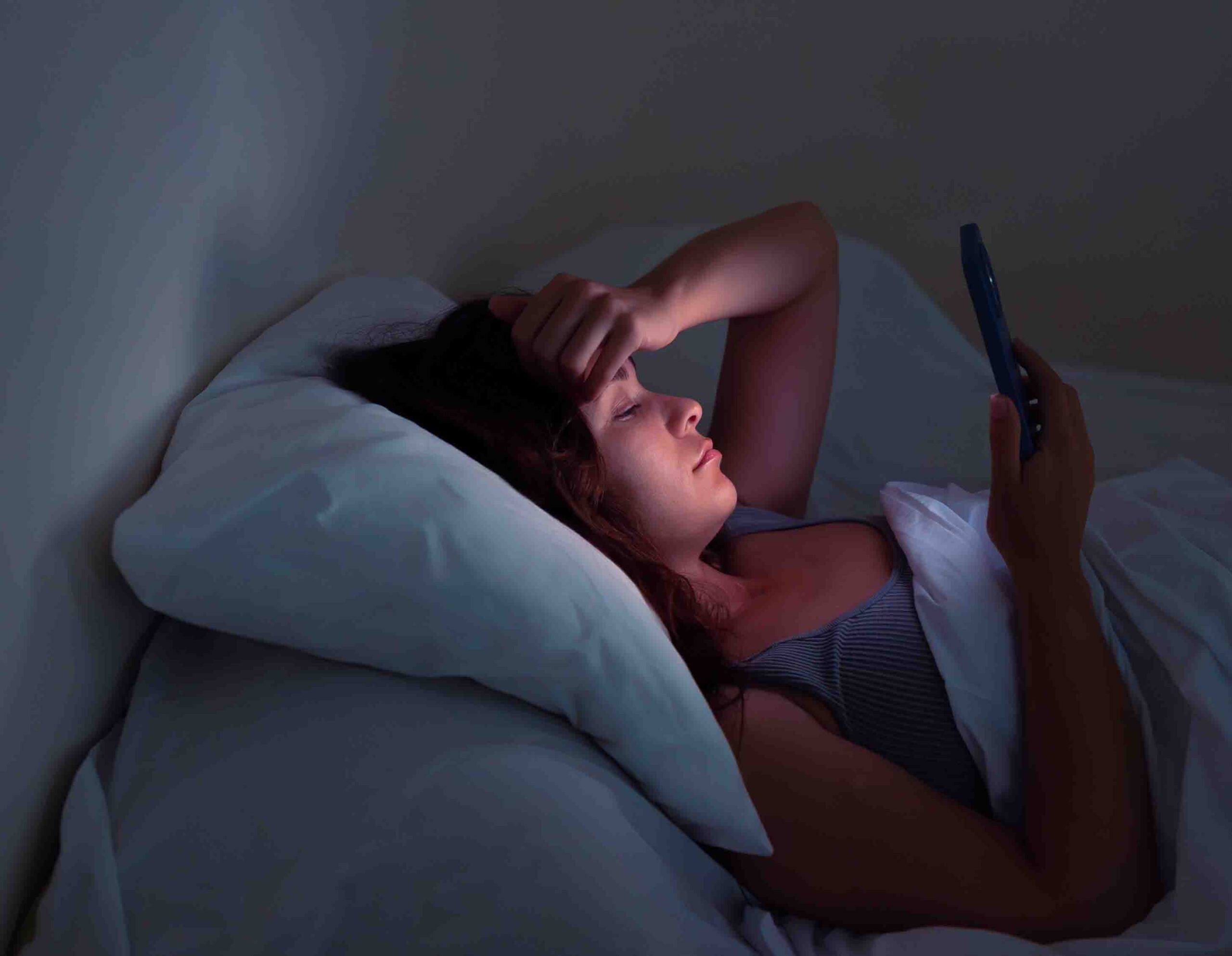 Donna a letto con difficolt&agrave; ad addormentarsi, insonnia legata a stress e cattive abitudini
