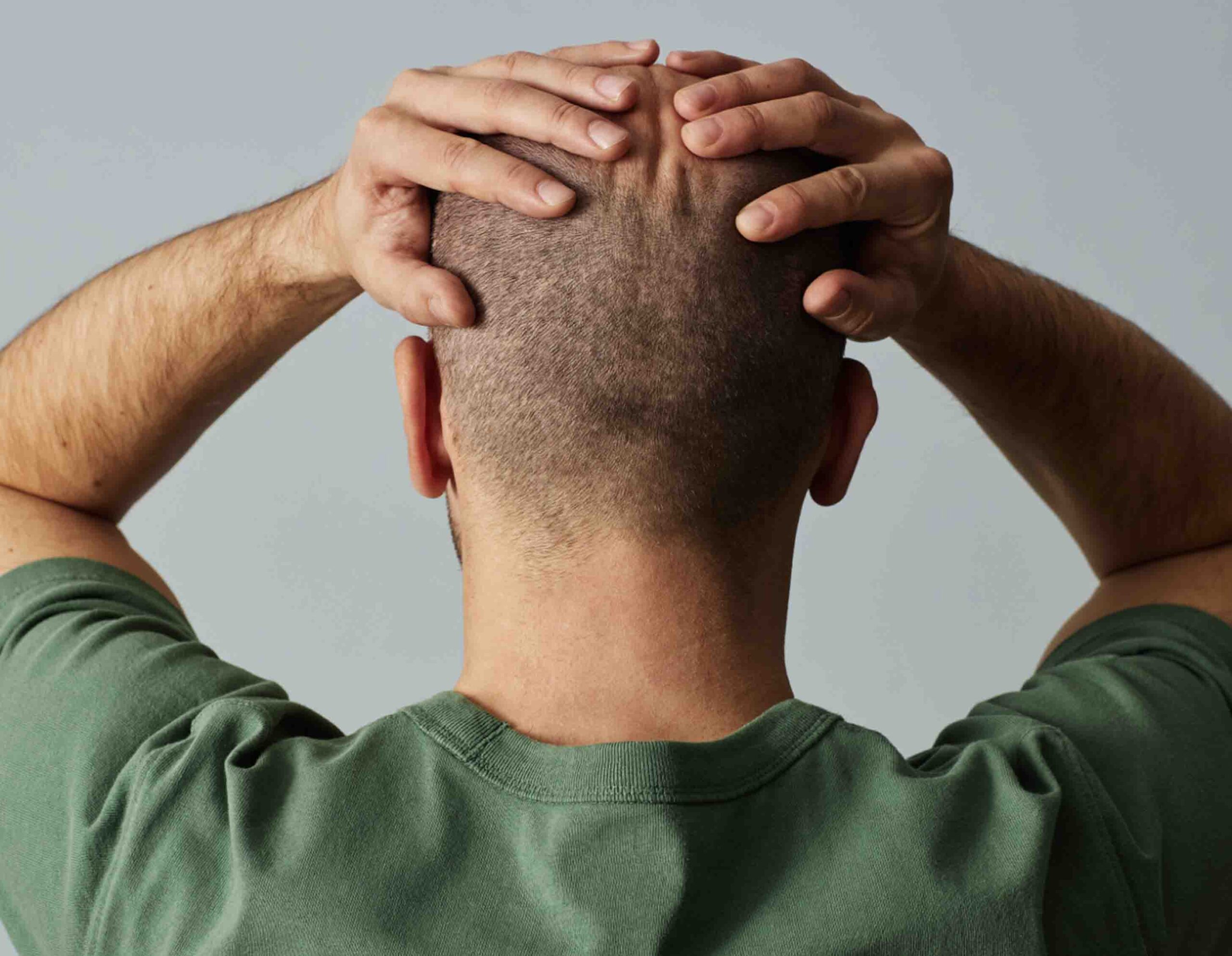 Uomo che si tiene la testa per dolore, sintomo tipico di mal di testa o cefalea
