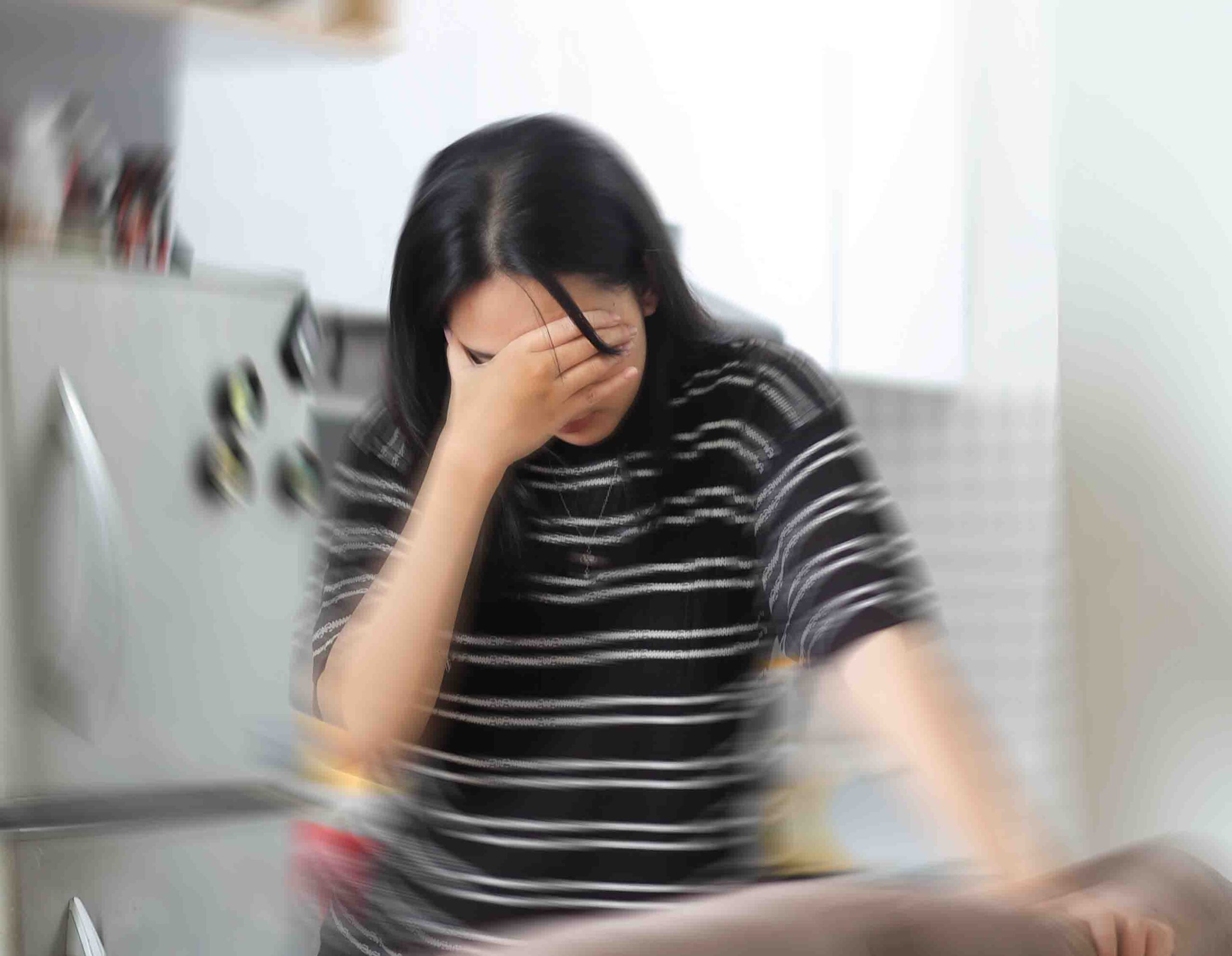 Donna con capogiro che si regge al divano, sintomo di vertigini e senso di instabilit&agrave;