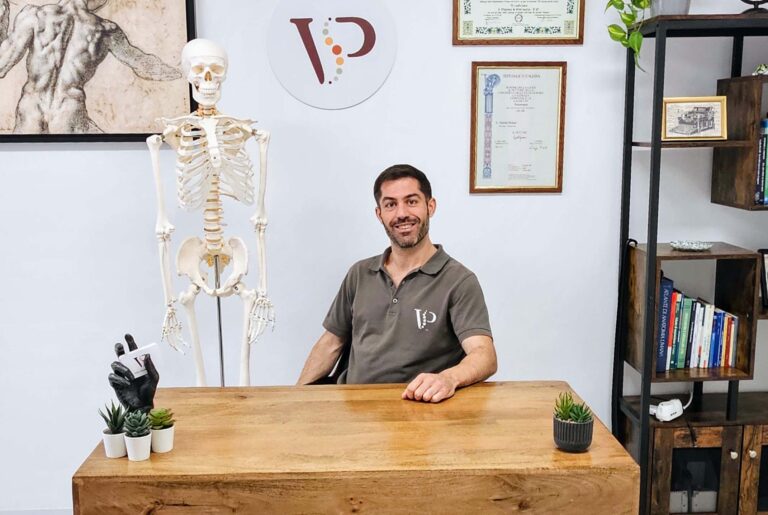 Valerio Puliani osteopata a Roma seduto alla scrivania nel suo studio